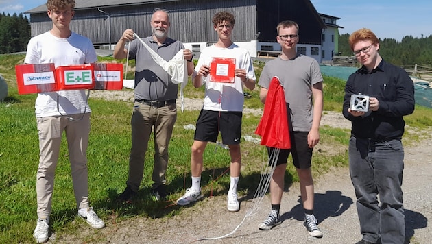 Die vier Schüler und einer der Professoren mit dem Satelliten (Bild: zVg)