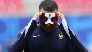 Kylian Mbappe zeigt seine Maske (Bild: AFP or licensors)