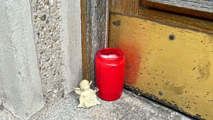 A tanácstömb bejárata előtt egy magányos gyertya emlékezik a tragédiára.