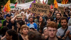 „Touristen, geht nach Hause“, steht auf dem Schild einer Demonstrantin in Barcelona. (Bild: AP ( via APA) Austria Presse Agentur/Emilio Morenatti)