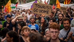 „Touristen, geht nach Hause“, steht auf dem Schild einer Demonstrantin in Barcelona. (Bild: AP ( via APA) Austria Presse Agentur/Emilio Morenatti)