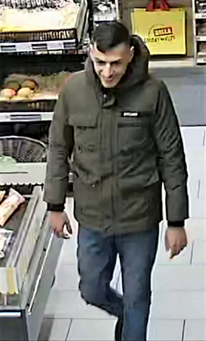 Der Räuber am Weg zum Kassapult in der Tankstelle in Linz