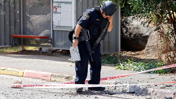 Ein Mitglied der Sicherheitskräfte begutachtet den Einschlagsort einer Hisbollah-Rakete im ...