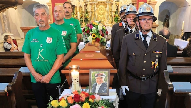 Fußballfreunde und Kameraden der Feuerwehr am Sarg des Verstorbenen. (Bild: Peter Tomschi)