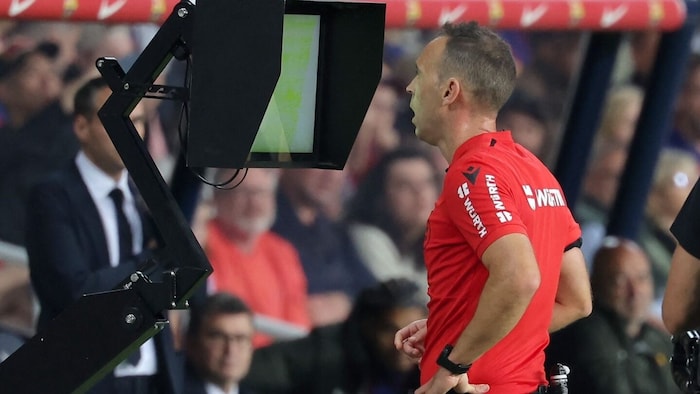 Now part of professional soccer: The referee studying the video during the match.