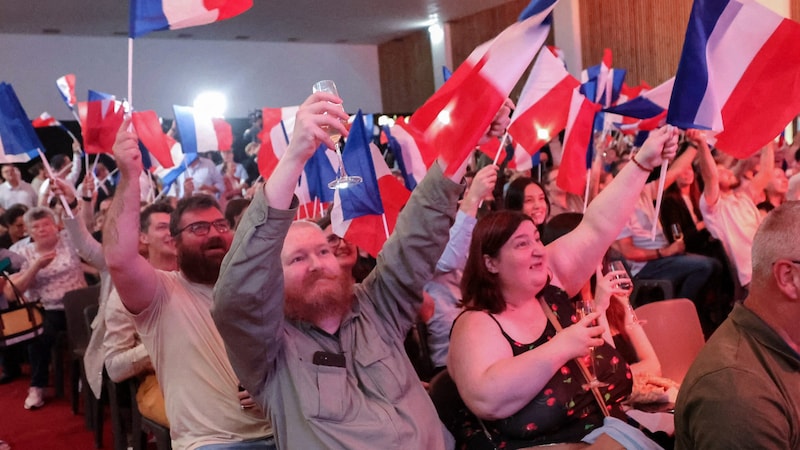 Kutlama nedeni: Marine Le Pen'in sağ popülist partisi RN'nin destekçileri ilk tahminlerin yayınlanmasının ardından Fransız bayrakları salladı. (Bild: AFP)