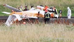 Fotos zeigen das auf dem Kopf liegende kleine Flugzeug vom Typ Cessna 172 zwischen den Fahrbahnteilern aus Beton in der Mitte der Autobahn. (Bild: AFP)