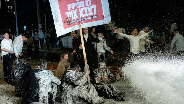 Protestanten machten im Jerusalemer Stadtteil Mea Sharim ihren Unmut über die Verpflichtung ultraorthodoxer Juden zum Wehrdienst Luft – die Polizei setzte Wasserwerfer ein. (Bild: APA/Associated Press)