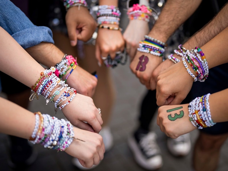 Swifties show off their friendship bracelets. (Bild: AP ( via APA) Austria Presse Agentur/Scott A Garfitt/Invision)