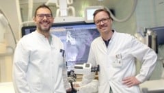 Alexander Loizides und Gerlig Widmann mit dem Roboter.  (Bild: Innsbrucker Univ.-Klinik für Radiologie)