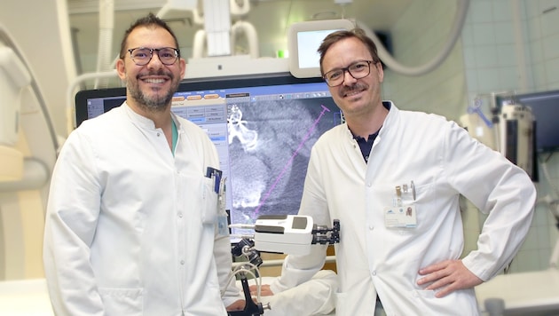 Alexander Loizides und Gerlig Widmann mit dem Roboter.  (Bild: Innsbrucker Univ.-Klinik für Radiologie)