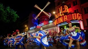 Das berühmte Pariser Kabarett Moulin Rouge erhielt am Freitag seine rote Windmühle im Rahmen einer feierlichen Zeremonie mit Cancan-Tanz auf dem Vorplatz zurück. (Bild: AP ( via APA) Austria Presse Agentur/Thibault Camus)
