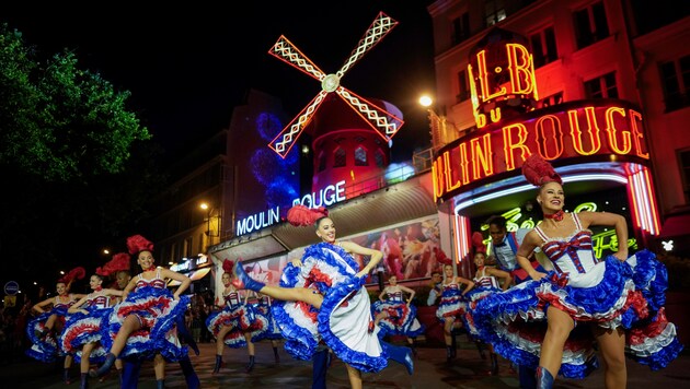 Paris'in ünlü kabaresi Moulin Rouge, Cuma günü ön avlusunda kankan dansı eşliğinde düzenlenen şenlikli bir törenin parçası olarak kırmızı yel değirmenini geri aldı. (Bild: AP ( via APA) Austria Presse Agentur/Thibault Camus)