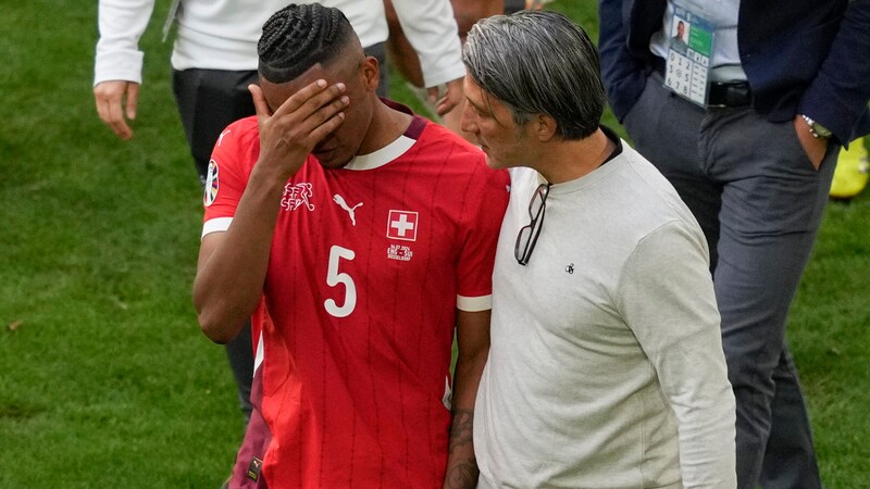 Coach Murat Yakin (right) tries to console Manuel Akanji. (Bild: AP ( via APA) Austria Presse Agentur/ASSOCIATED PRESS)