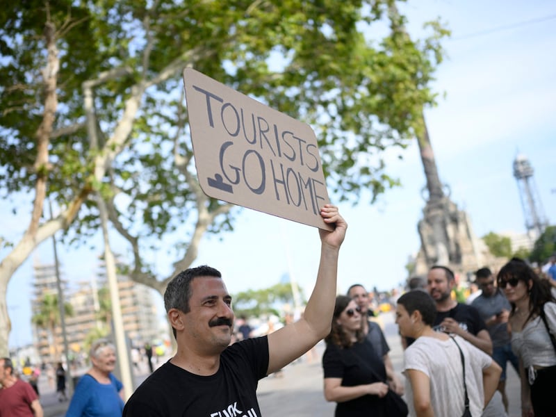 "Get lost", this demonstrator tells the hated tourists in slightly nicer words. (Bild: APA/Josep LAGO / AFP)