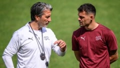 Trainer Murat Yakin (links) im Gespräch mit Kapitän Granit Xhaka.  (Bild: AFP/APA/Fabrice COFFRINI)