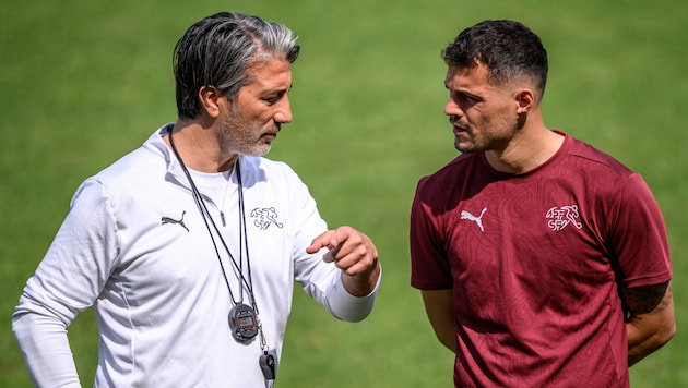 Trainer Murat Yakin (links) im Gespräch mit Kapitän Granit Xhaka.  (Bild: AFP/APA/Fabrice COFFRINI)