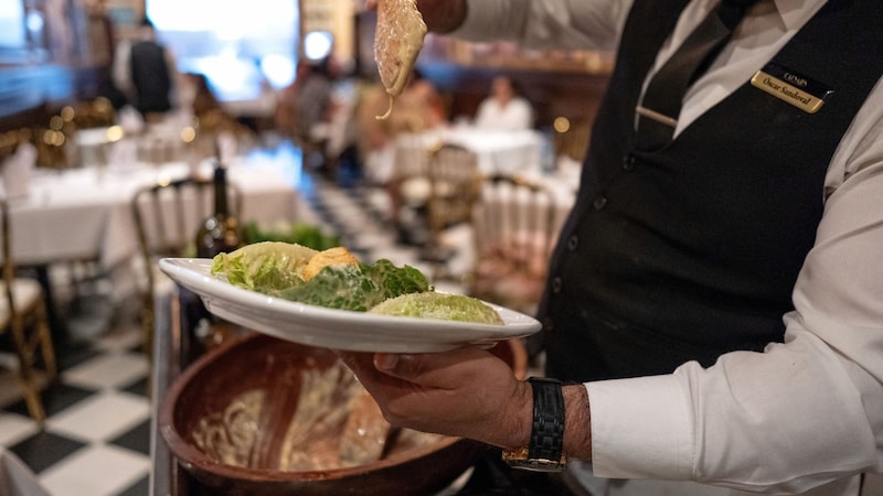 A tijuanai "Caeser's Restaurant" egyik pincére elkészítette a legendás salátát, és éppen tálalni készül. (Bild: APA/Guillermo Arias / AFP)