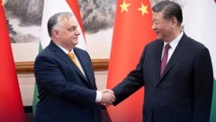 Ungarns Präsident Viktor Orban (links) schüttelt dem chinesischen Präsidenten Xi Jinping (rechts) in Peking die Hand. (Bild: APA/AFP/X ACCOUNT OF HUNGARY‘S PRIME)