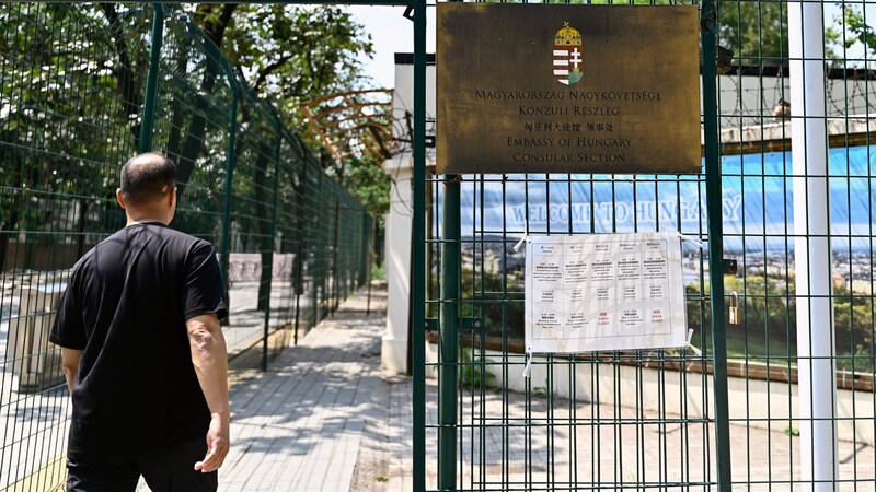 Ein Mann betritt am Montag die Konsularabteilung der ungarischen Botschaft in Peking. (Bild: APA/AFP/Pedro PARDO)