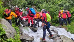 Bergretter bargen den Verletzten mit einer Gebirgstrage. (Bild: ZOOM Tirol/Krone KREATIV)