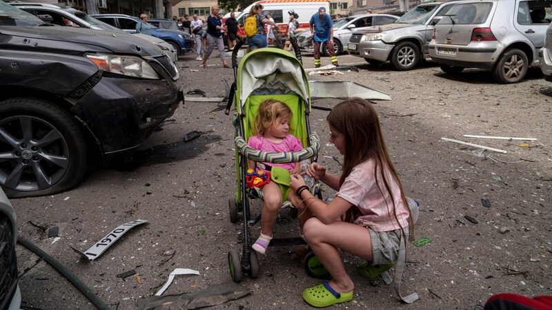 Kiev'de Rus füzeleri tarafından vurulan Okhmatdyt çocuk hastanesinin yakınında bekleyen çocuklar. (Bild: Associated Press)