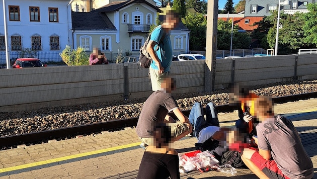 Successful: the train driver and witnesses attend to the injured man. Meanwhile, at the back of the fence, a grumbler is interrupting with his tirades. (Bild: Krone KREATIV/zVg)