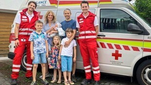 Die Sanitäter Florian Schöpf (li.) und Daniel Köll mit der sechsköpfigen Familie Senfter.