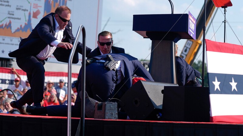 Immediately after the first shot, Secret Service men rush to Trump. (Bild: AP ( via APA) Austria Presse Agentur/Copyright 2024 The Associated Press. All rights reserved)