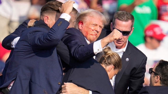 Trump is combative, raises his fist in the air and shouts: "Fight!"