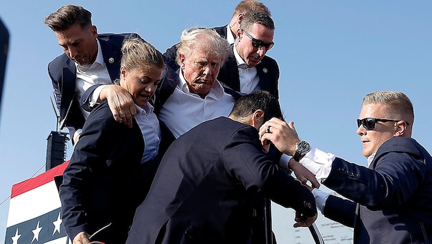 Donald Trump is carried off the stage to safety, injured. (Bild: APA/Getty Images via AFP/GETTY IMAGES/Anna Moneymaker)