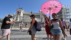 Eine Frau schützt sich in Rom mit einem Schirm vor der Sonne. (Bild: AFP/Andreas Solaro)