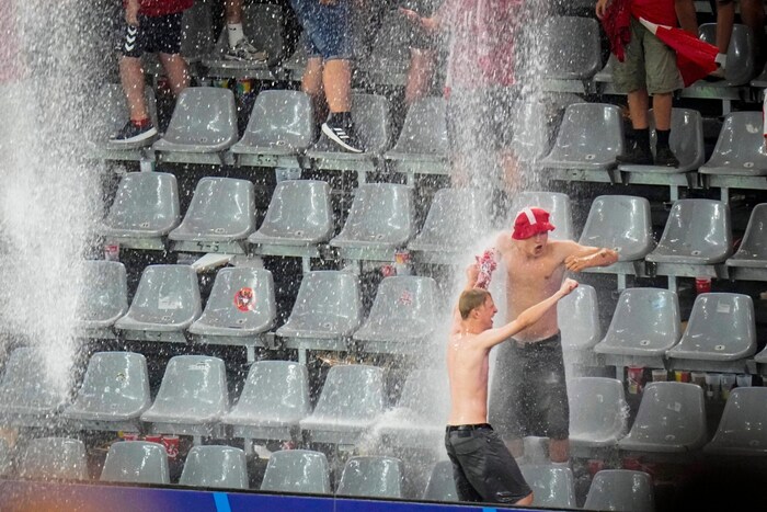 Diese dänischen Fans genossen die Gewitter-Dusche beim Achtelfinale gegen Deutschland.