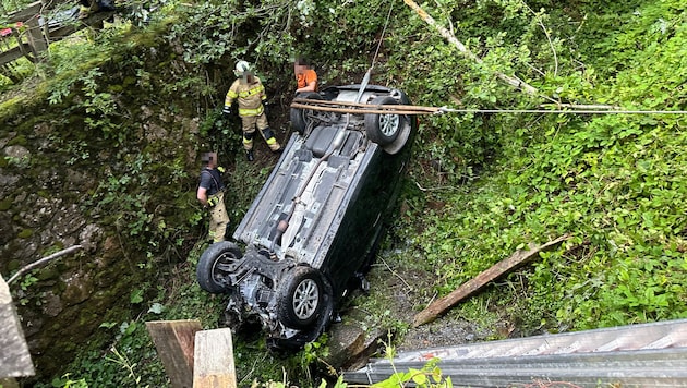 The car came to a standstill lying on its roof in the stream. It had to be rescued by the fire department. (Bild: ZOOM Tirol/Krone KREATIV)