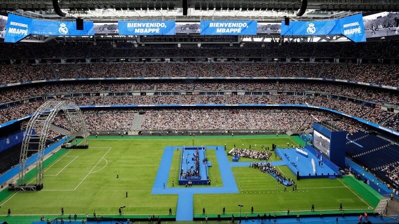 Fußball-Superstar Kylian Mbappé ist bei seiner offiziellen Vorstellung als Neueinkauf von Real Madrid von 85.000 Fans im Estadio Santiago Bernabéu begeistert empfangen worden. (Bild: AFP/APA/OSCAR DEL POZO)