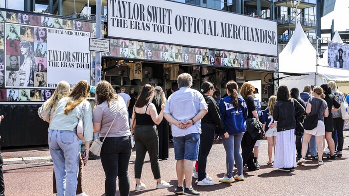 „Swifties“ stehen Schlange vor einem der offiziellen Fanshops außerhalb des Geländes der Veltins-Arena.