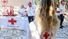 Mitarbeiter des Roten Kreuzes verteilen auf dem Akropolis-Gelände Wasserflaschen an Touristen. (Bild: AFP or licensors)