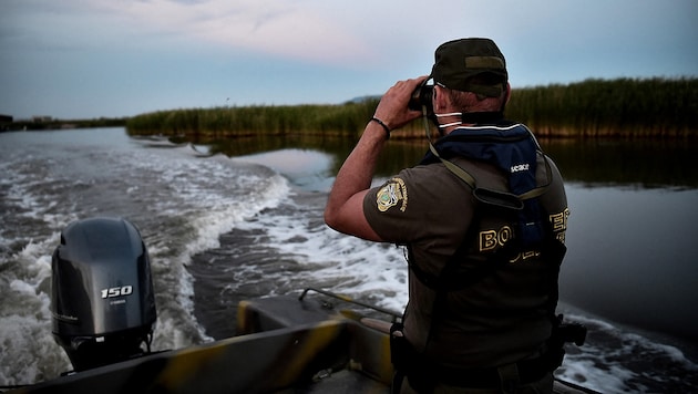 Ein griechischer Grenzschützer patrouilliert auf dem Fluss Evros. (Bild: APA/AFP/Sakis MITROLIDIS)