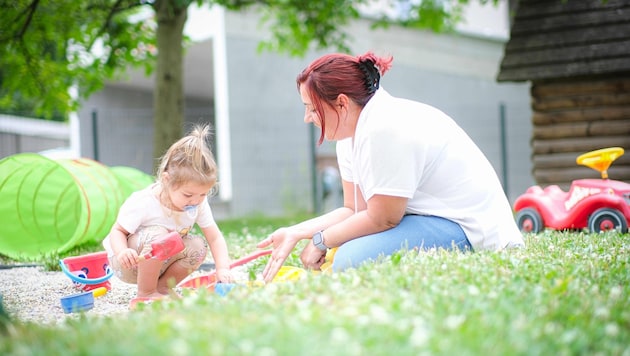 Childminder Michaela Kaksa playing in the sand with Lara (2). (Bild: Einöder Horst)