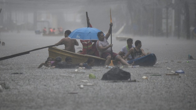 In der Hauptstadt Manila sind Menschen mit Booten unterwegs.  (Bild: AFP/Ted ALJIBE)