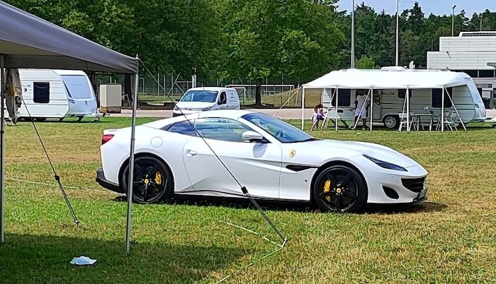 Kann man machen: Der Ferrari parkt auf der Wiese vorm Wohnwagen-Vorzelt.