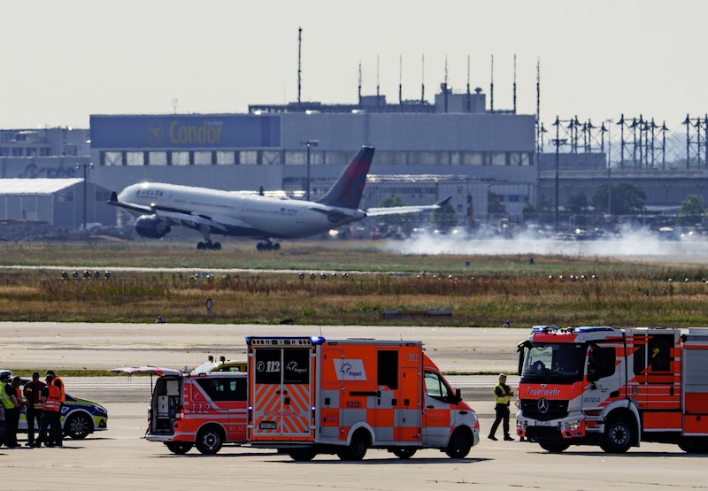 Während sich noch die Einsatzkräfte der Polizei und der Flughafenfeuerwehr mit den Klima-Aktivisten auseinandersetzen, landeten bereits die ersten Flugzeuge wieder. (Bild: APA/dpa/Andreas Arnold)