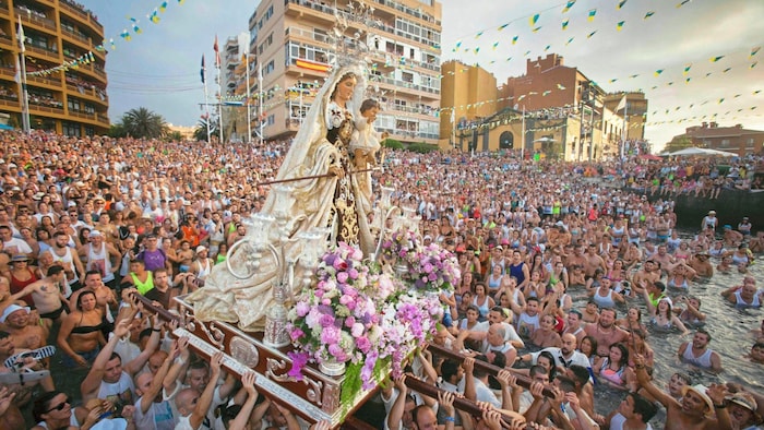 Begleitet von Gesängen wird die Virgen del Carmen im Hafen von Puerto de la Cruz ins Wasser ...