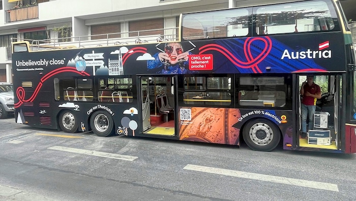 Der elektrische Doppeldecker wirbt für Urlaub in Österreich.
