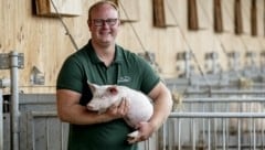 Öko-Züchter Manuel Hauer mit einem zufriedenen Ferkel (Bild: Imre Antal)