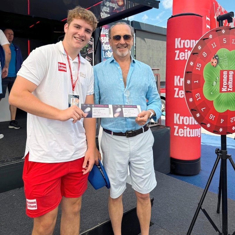 Tennisfan Damian Bourke aus Yorkshire (re.) drehte kurzerhand am „Krone“- Glücksrad und gewann prompt zwei Tagestickets. Sie wurden ihm von Mathias überreicht. (Bild: Tiroler Krone)