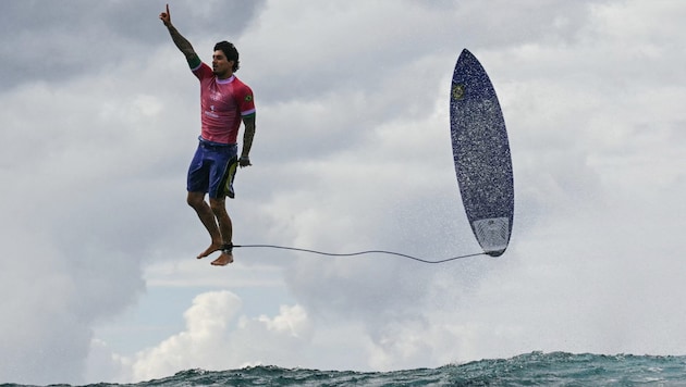 Ein jetzt schon ikonisches Bild: der „fliegende Surfer“ der Olympischen Spiele von Paris. (Bild: AFP/APA/Jerome BROUILLET)