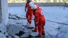 Rotkreuz-Mitarbeiter begutachten Schäden nach einem israelischen Angriff im Südlibanon. (Bild: AFP/Rabih Daher)