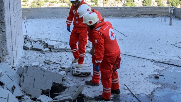 Rotkreuz-Mitarbeiter begutachten Schäden nach einem israelischen Angriff im Südlibanon. (Bild: AFP/Rabih Daher)