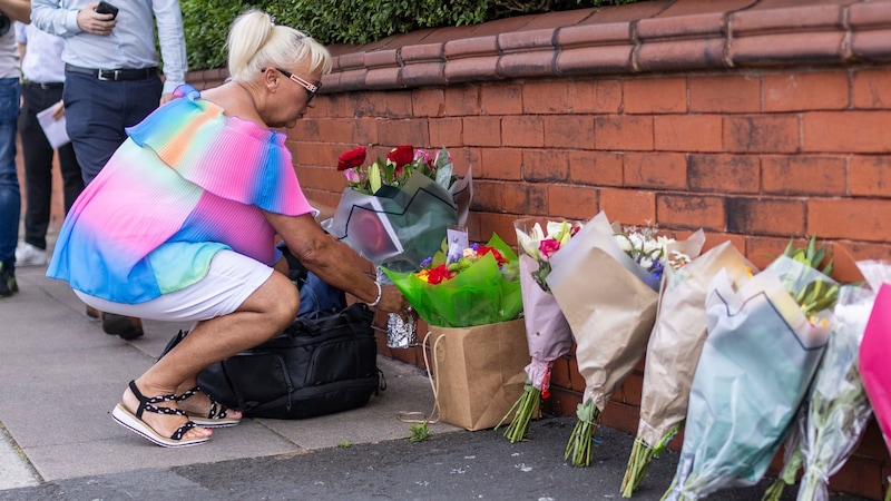 Mourners lay flowers. (Bild: AP ( via APA) Austria Presse Agentur/James Speakman)